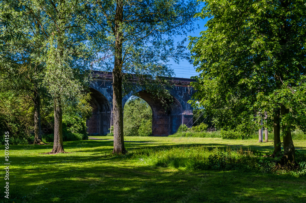 A view through trees towards the fourteen arches viaduct at Wolverton, UK in summertime