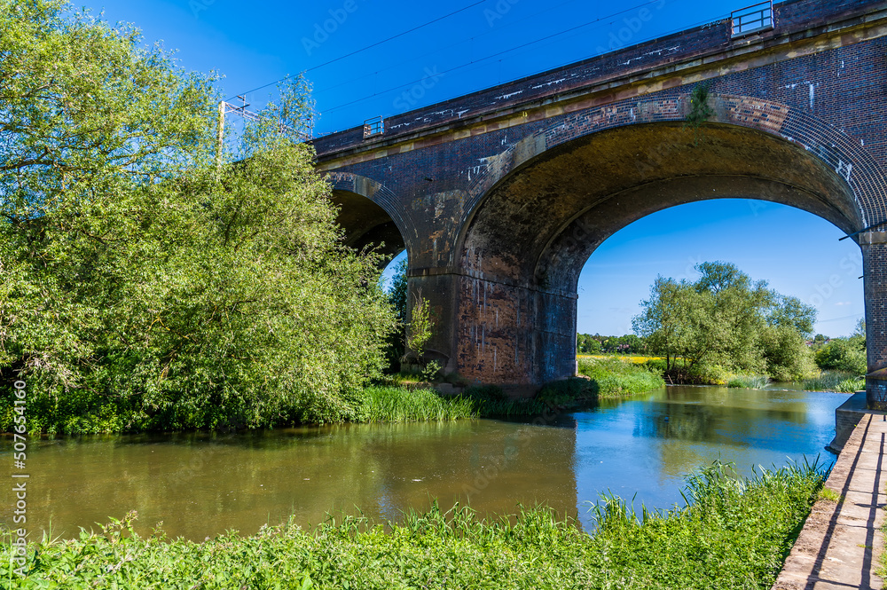 A view down the river Great Ouse towards the fourteen arches viaduct at Wolverton, UK in summertime
