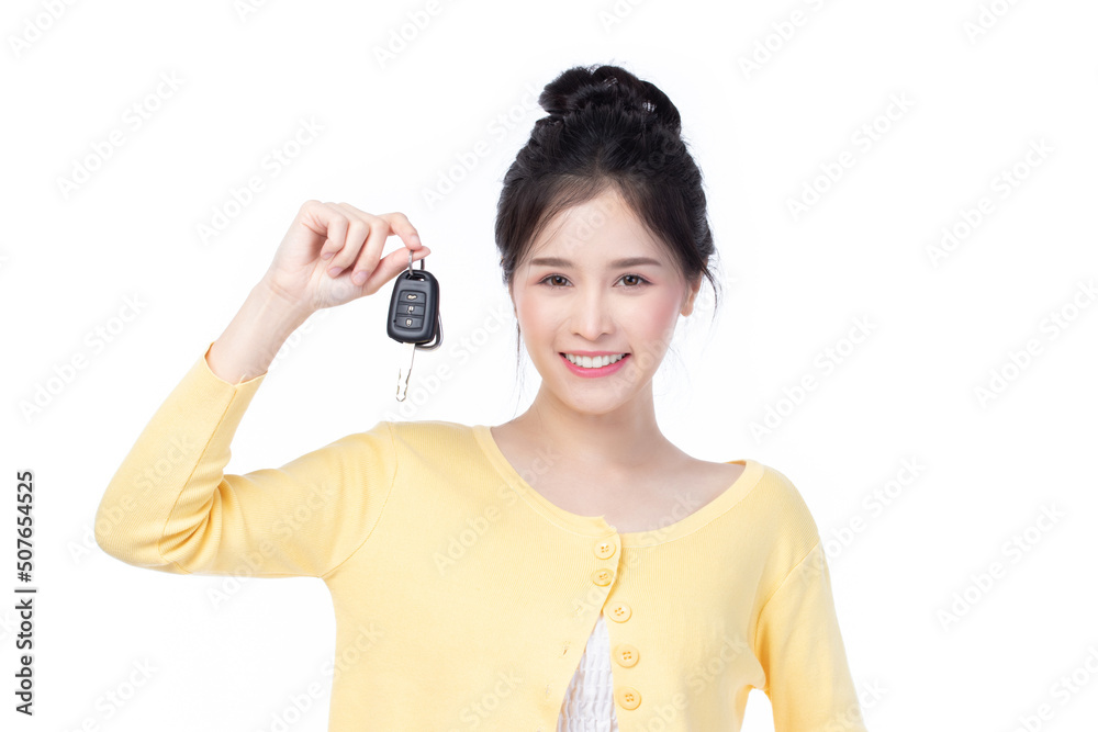 Beautiful young Asian woman wearing yellow shirt feeling happy and smile holding the keys of the car on white background. Beautiful young Asian woman wearing yellow shirt feeling happy and smile holding the keys of the car on white background.