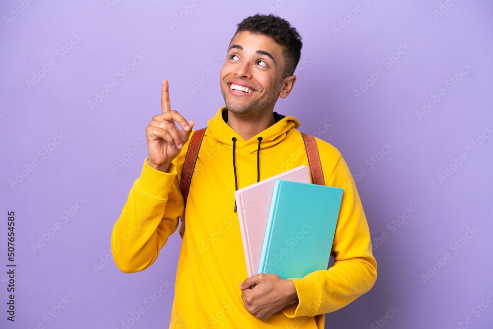 Young student Brazilian man isolated on purple background pointing up a great idea - obrazy, fototapety, plakaty 
