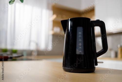 Cuadro en lienzo Modern black electric kettle on kitchen table