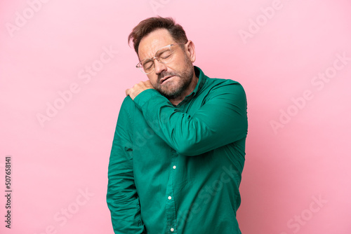 Middle age caucasian man isolated on pink background suffering from pain in shoulder for having made an effort © luismolinero