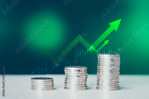 Coins stack of money on saving, the step of the financial stock market, graph and rows of coins, business investment on a green background, Economy stock market growth of financial recovery..