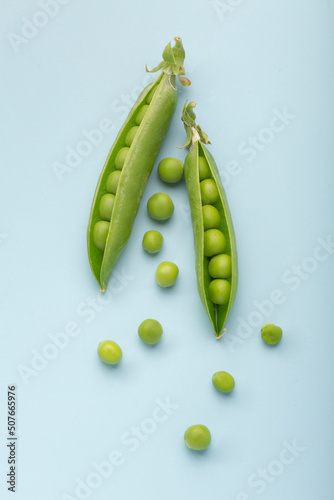 Fresh green peas on blue background. Flat lay. Top view