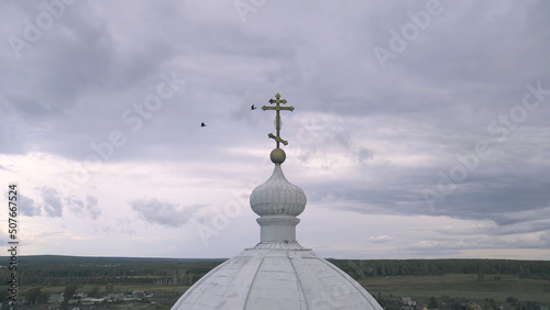 Man and woman look at dome of Church. Stock footage. Man and believing woman stand on balcony of Church and look at dome with cross