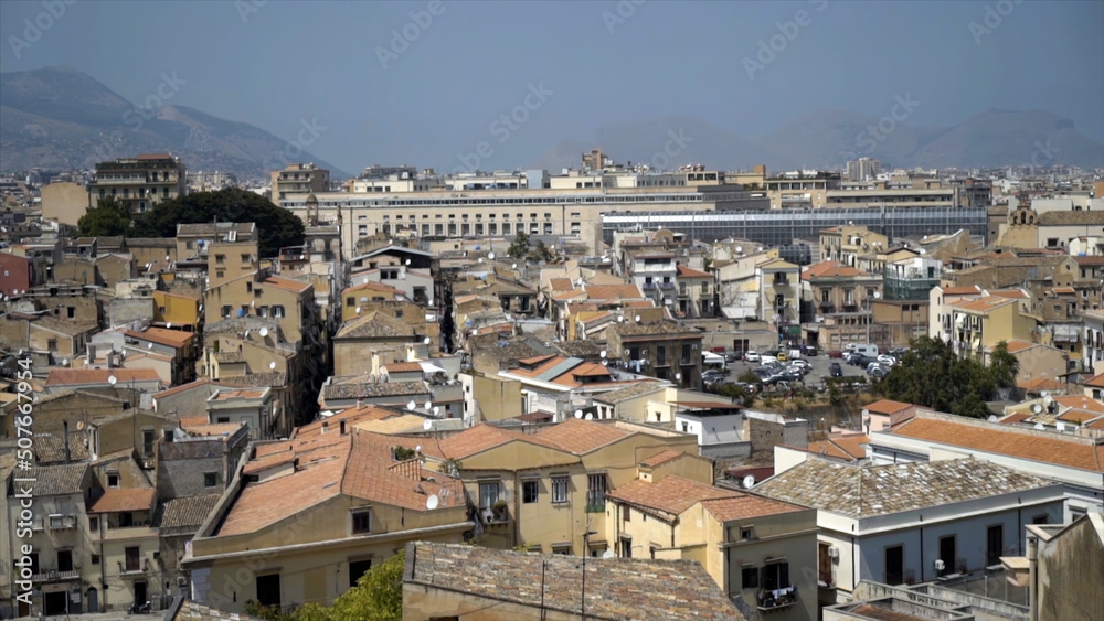 Panoramic view of old European city with slum houses. Action. Yellow houses of old southern city on background of mountain panorama and sky