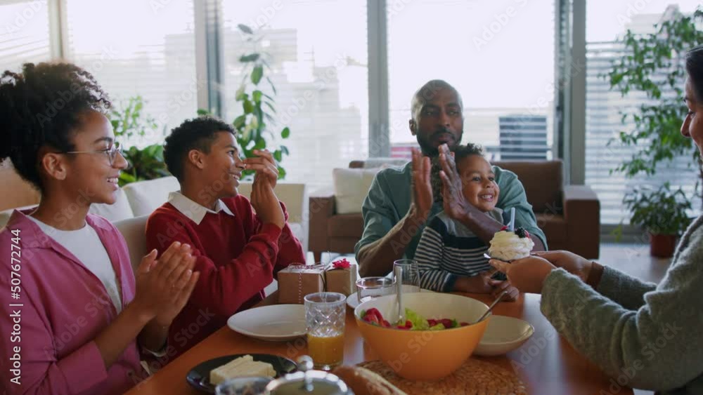 Little multiracial boy celebrating birthday with his family at home. Little multiracial boy celebrating birthday with his family at home.