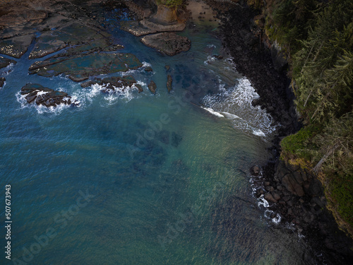 View from above. Blue water surface, rocky shore covered with moss. Calm scenes, beauty of nature. Geology, biology, ecology, environmental protection. Changing of the climate.