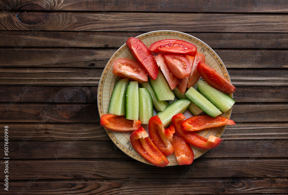 Cut vegetables - tomato, pepper, cucumber on a wooden board Cut vegetables - tomato, pepper, cucumber on a wooden board