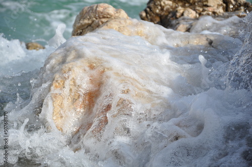 Sea, big wave and splash over the stones.Wave splashing on a Croatian beach on early summer. Waves splashing into white rocks on the coast of Rijeka beach Pecine. big wave and splash over the stone photo