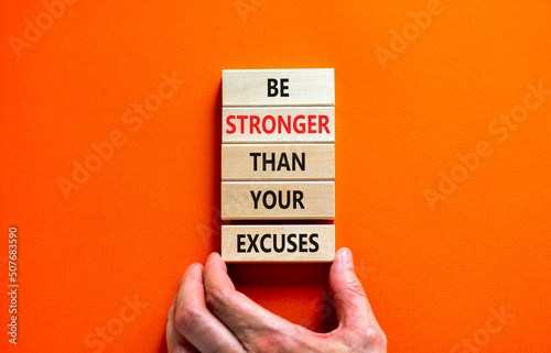 Be stronger symbol. Concept words Be stronger than your excuses on wooden blocks on a beautiful orange table orange background. Businessman hand. Business motivational and be stronger concept.