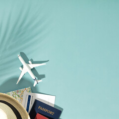 Miniature toy airplane, travel accessories and paper clouds on blue background. Flat lay design of travel concept