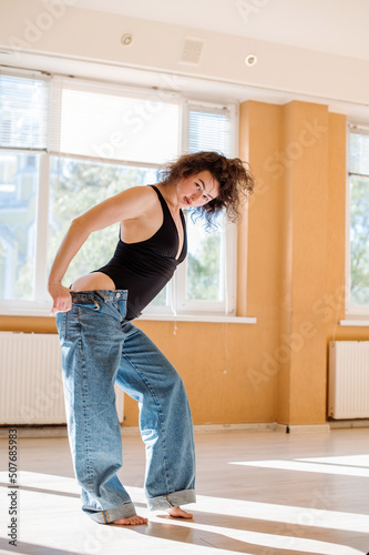 Dancer woman in bodysuit posing in dancing studio