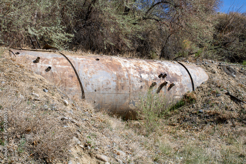 Rusty Cold War style abandoned bomb shelter half in the ground in the state of Wyoming created from large Oil Piping from Apocalypse in Case of Nuclear War