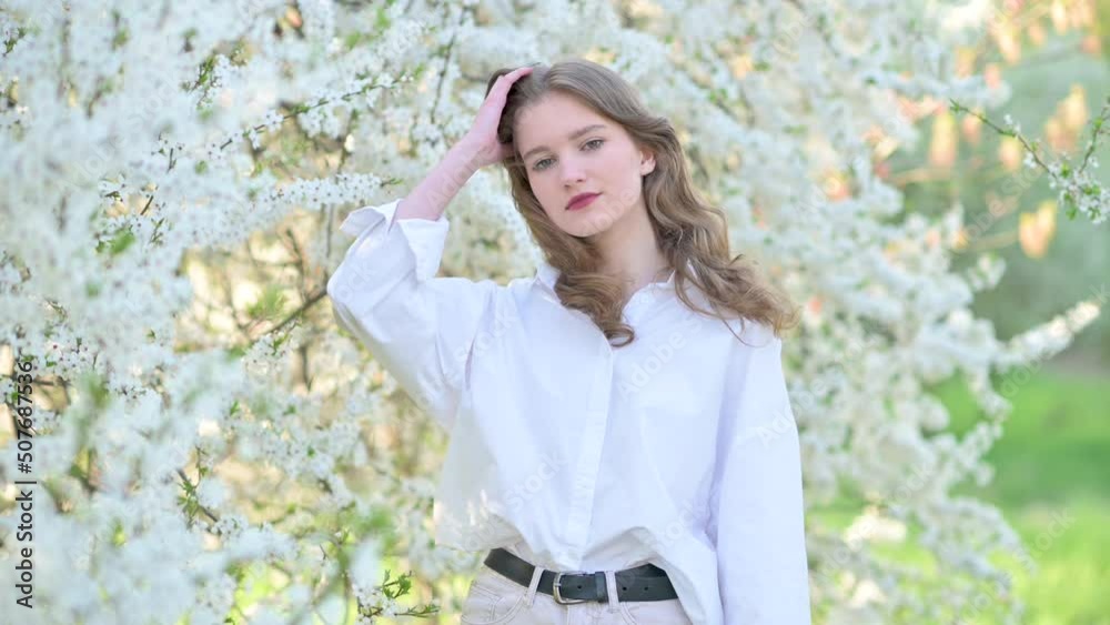 Portrait of a cute young girl in a beautiful blooming garden. Happy beautiful girl in garden with blooming trees. Beauty model girl face. Portrait of a cute young girl in a beautiful blooming garden. Happy beautiful girl in garden with blooming trees. Beauty model girl face.