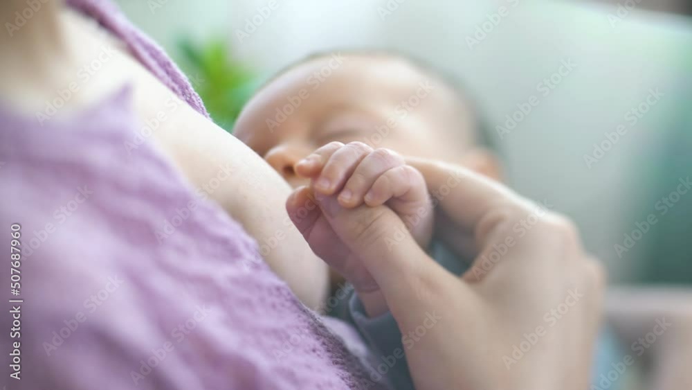 A young mother breastfeeds a newborn baby in a light bedroom. Mom holding her Baby and hugging. Maternity, Parenthood and Motherhood. Beautiful Happy Family. Close-up, tilt shift lens A young mother breastfeeds a newborn baby in a light bedroom. Mom holding her Baby and hugging. Maternity, Parenthood and Motherhood. Beautiful Happy Family. Close-up, tilt shift lens