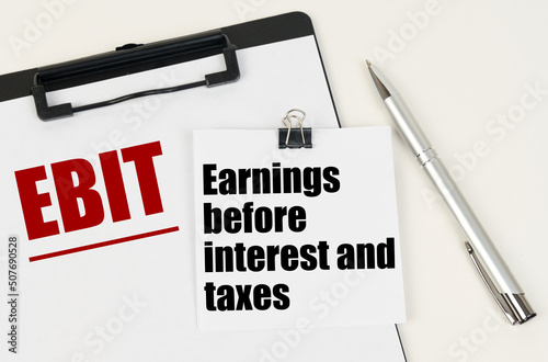 On the tablet, a sheet of paper and stickers with the inscription - EBIT, Earnings before interest and taxes photo