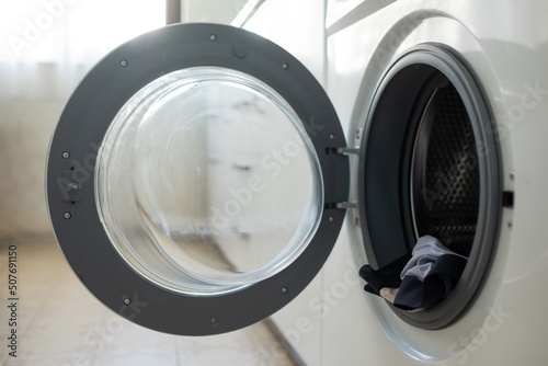 closeup of washing machine door with clothes in drum