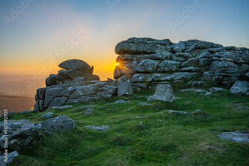 Sunburst through a granite tor, Dartmoor National Park, Devon, England, UK photo