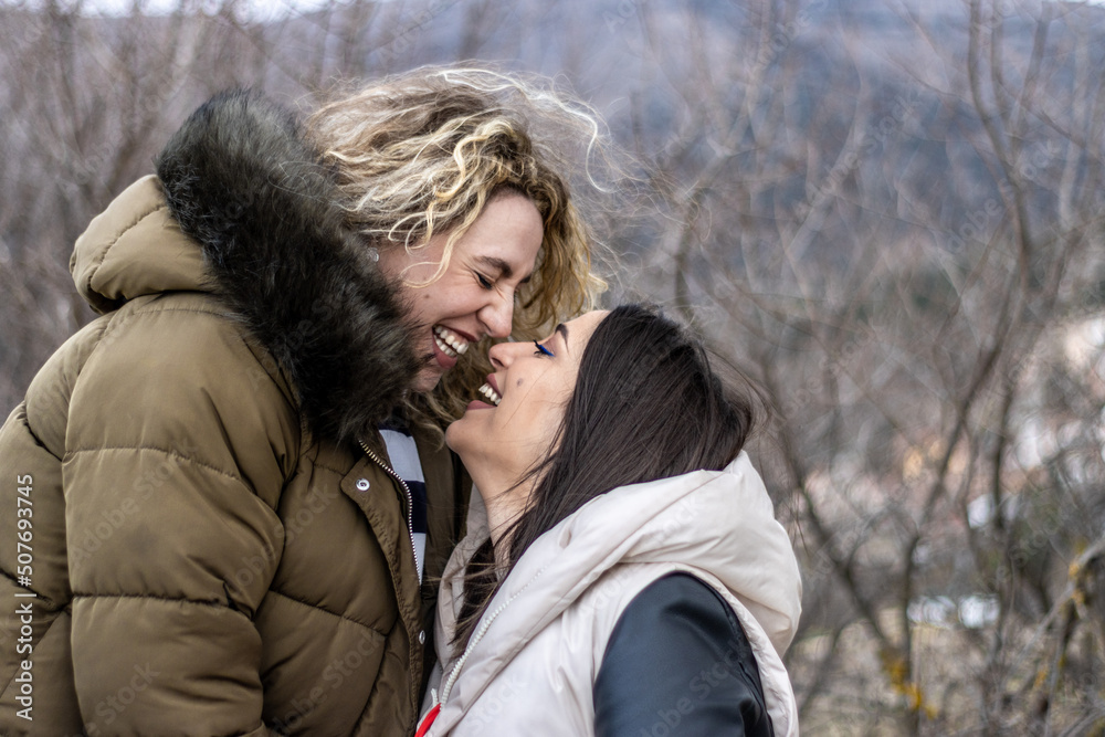 Fototapeta premium A lesbian couple spending a winter day together in the open air and laughing.