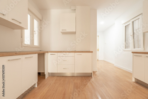 Newly installed kitchen cabinets with white cabinets  wooden countertops and matching flooring