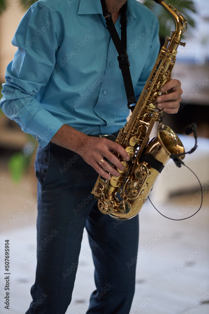 Naklejka premium The musician plays the saxophone close-up