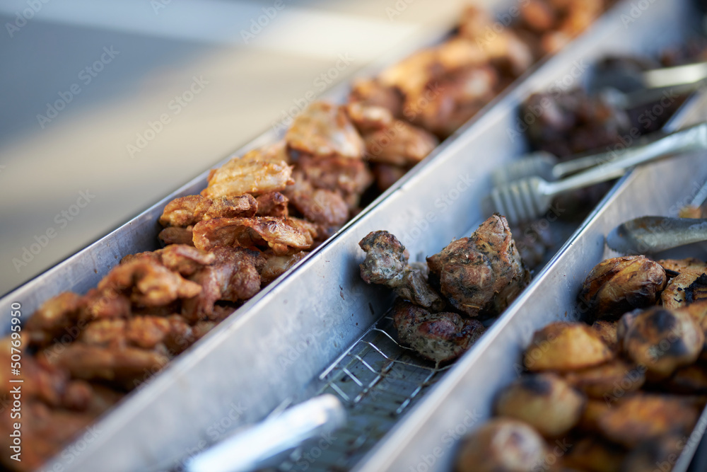 Grilled vegetables and chicken on distribution in iron trays , containers