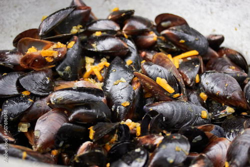 shellfish. Fresh mussels in a pan with parsley and lemon. Steamed mussels in white wine sauce