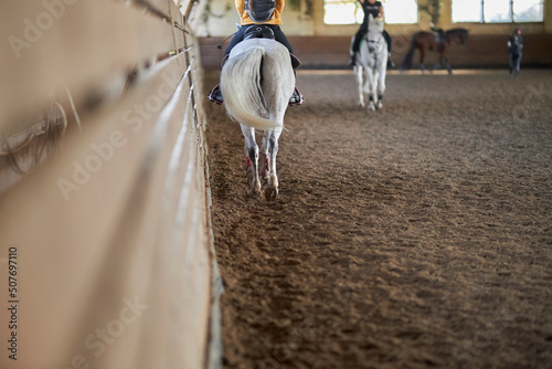 rider trains in riding a gray horse in the arena, cropped image