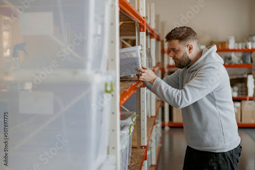 Entrepreneur inspect boxes of roasted coffee beans on a shelf in a warehouse