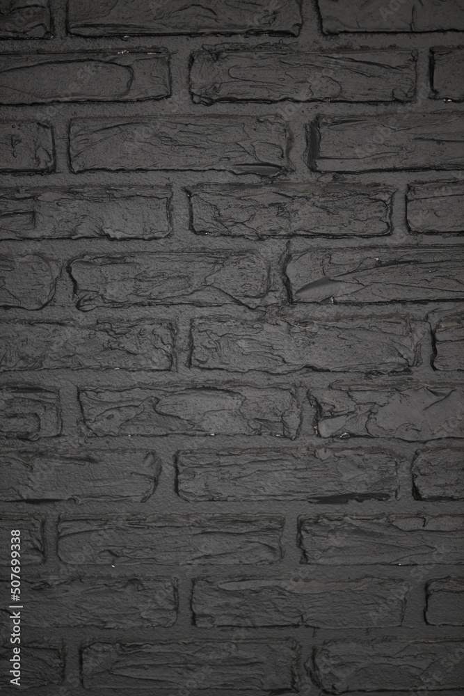 Texture of brick decorative wall in dark gray color 