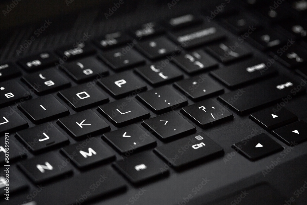 Close-up of computer keyboard, technological black and white background with selective focus