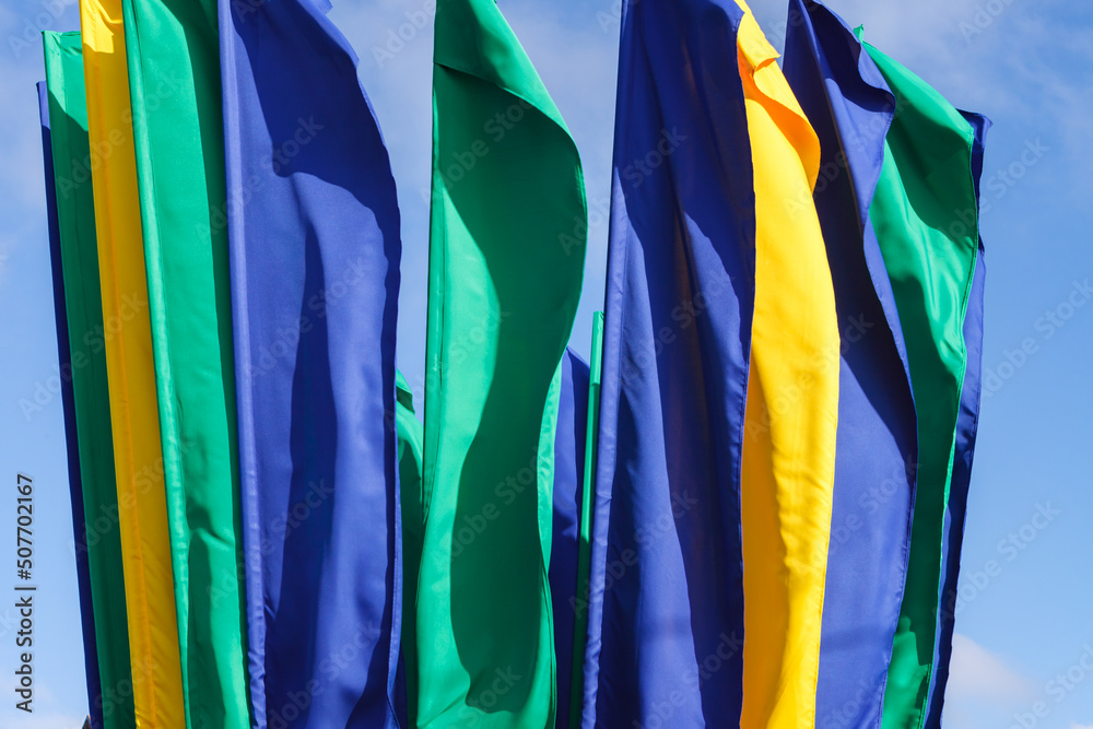 yellow, blue and green flags on the sky background