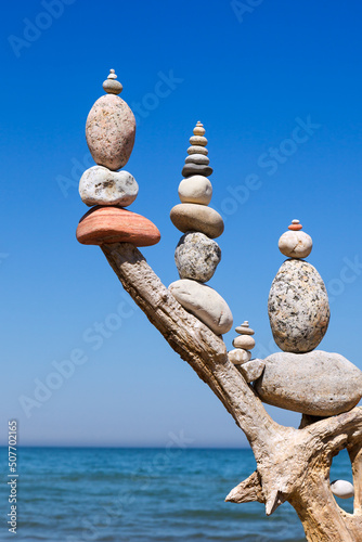 Photography Three Rock Zen pyramid of balanced stones on a background of the summer sea and