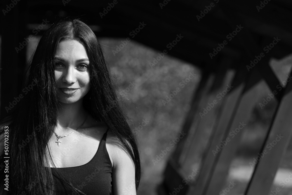 Black and white portrait of a beautiful girl in a wooden gazebo Black and white portrait of a beautiful girl in a wooden gazebo