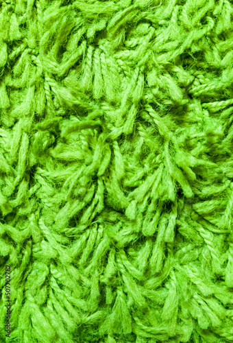 Green texture of pile  threads and wool. Close-up macro photo of the carpet