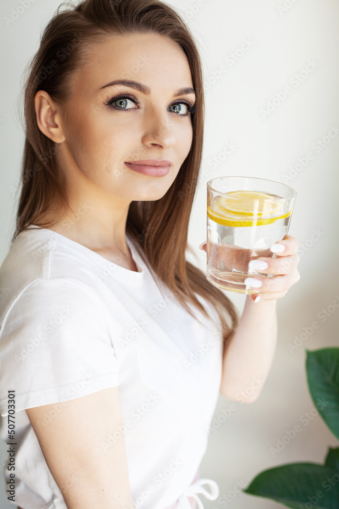 Calm youthful lady refreshing herself with lemon water Calm youthful lady refreshing herself with lemon water