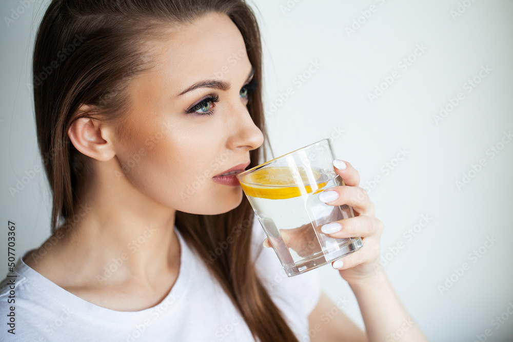 Calm youthful lady refreshing herself with lemon water Calm youthful lady refreshing herself with lemon water