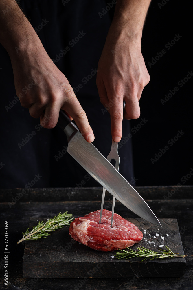 Cook cutting fresh meat on board