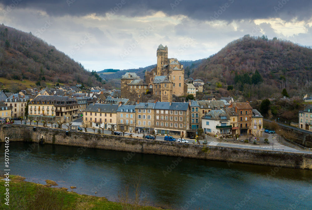 Aerial view of picturesque village of Estaing with medieval castle and gothique arched bridge across Lot river, Aveyron, France