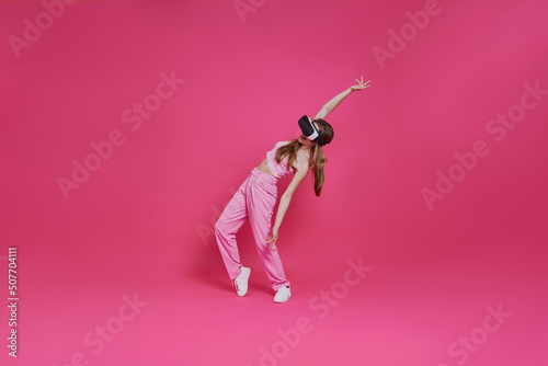 Full length of playful young woman in virtual reality headset having fun © gstockstudio