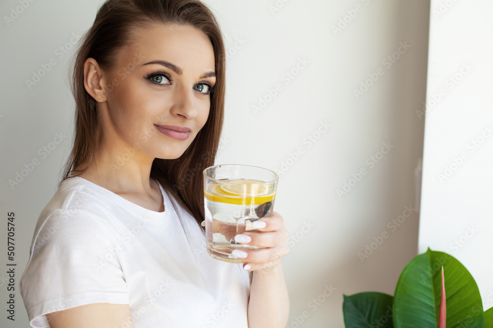 Calm youthful lady refreshing herself with lemon water Calm youthful lady refreshing herself with lemon water