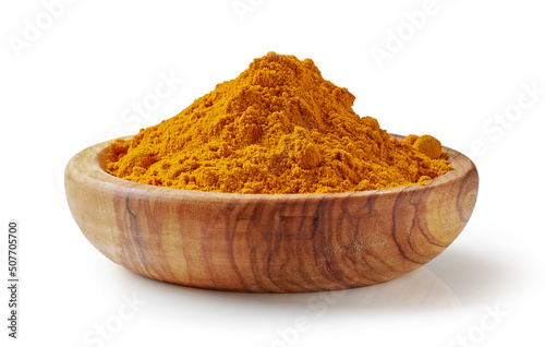 curry powder in olive wood bowl isolated on white background