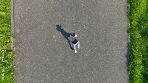 土手でジョギングする女性の空撮 真俯瞰