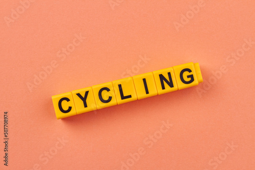 Word cycling written on yellow cubes against color background. Cycle riding concept.