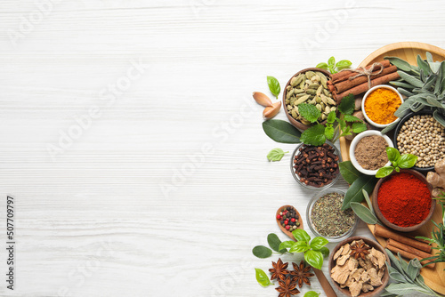 Fototapeta Naklejka Na Ścianę i Meble -  Different fresh herbs and spices on white wooden table, flat lay. Space for text