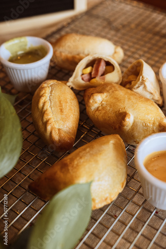 A table with empanadas and sauces