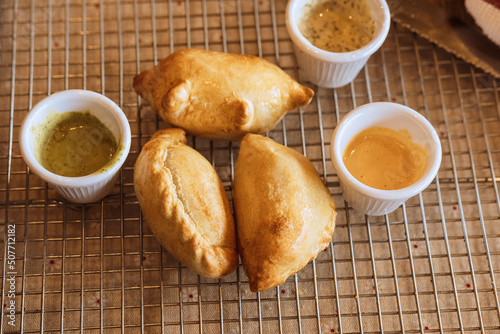 A table with empanadas and sauces