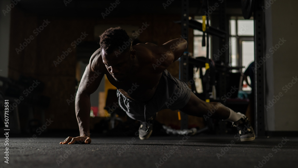 African american man doing one arm push ups in the gym. African american man doing one arm push ups in the gym.