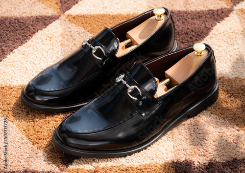 Men fashion leather black shoes loafers on the carpet.